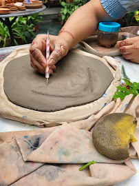 Hands drawing on clay slab